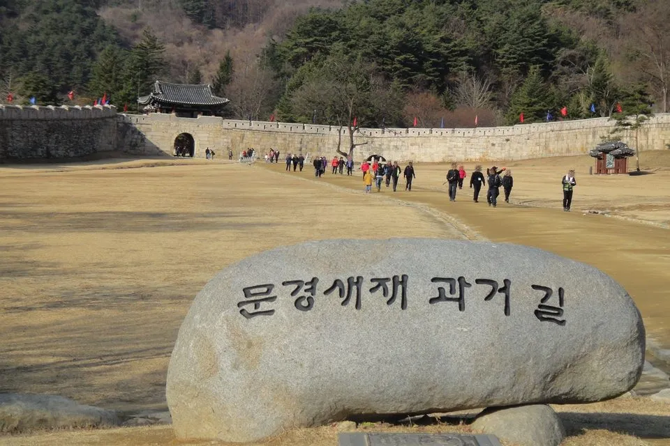 '문경새재 과거길' 표지석 뒤로 보이는 문경새재 제1관문 주흘관(사과축제가 열리는 문경새재도립공원)