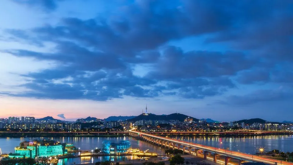 해 질 무렵 한강과 반포대교, 강 건너 아파트 단지가 보이는 서울 야경