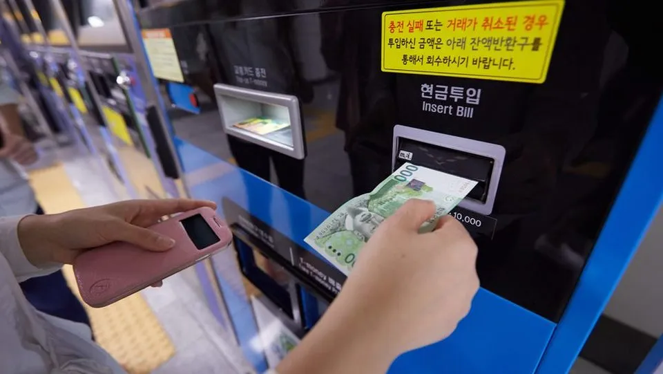 만 원권 지폐를 기계에 넣는 손