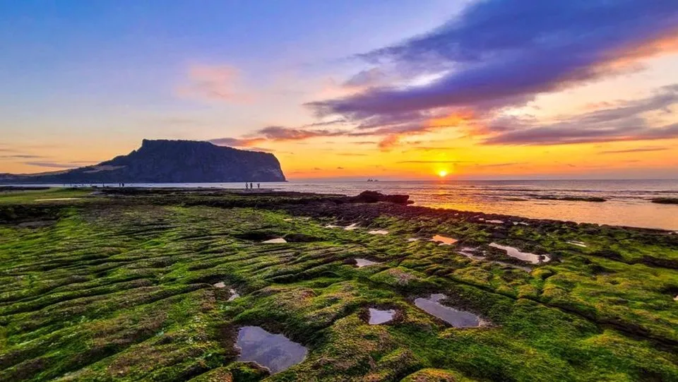 해 뜰 무렵 붉게 물든 하늘 아래 성산일출봉
